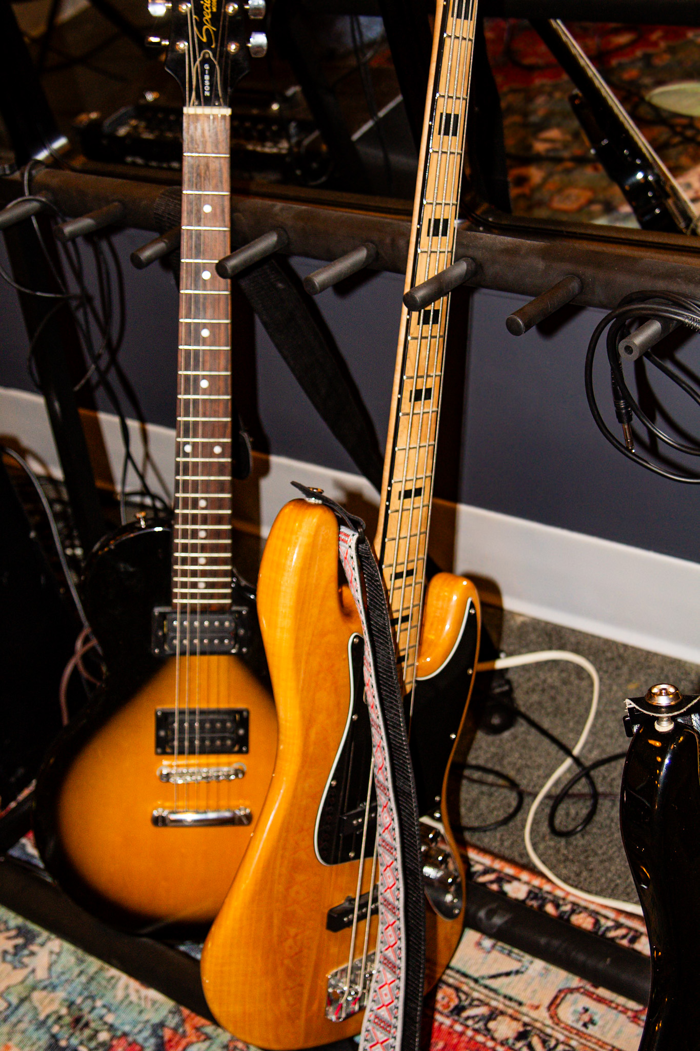 Electric and bass guitars racked and ready to grab in the studio