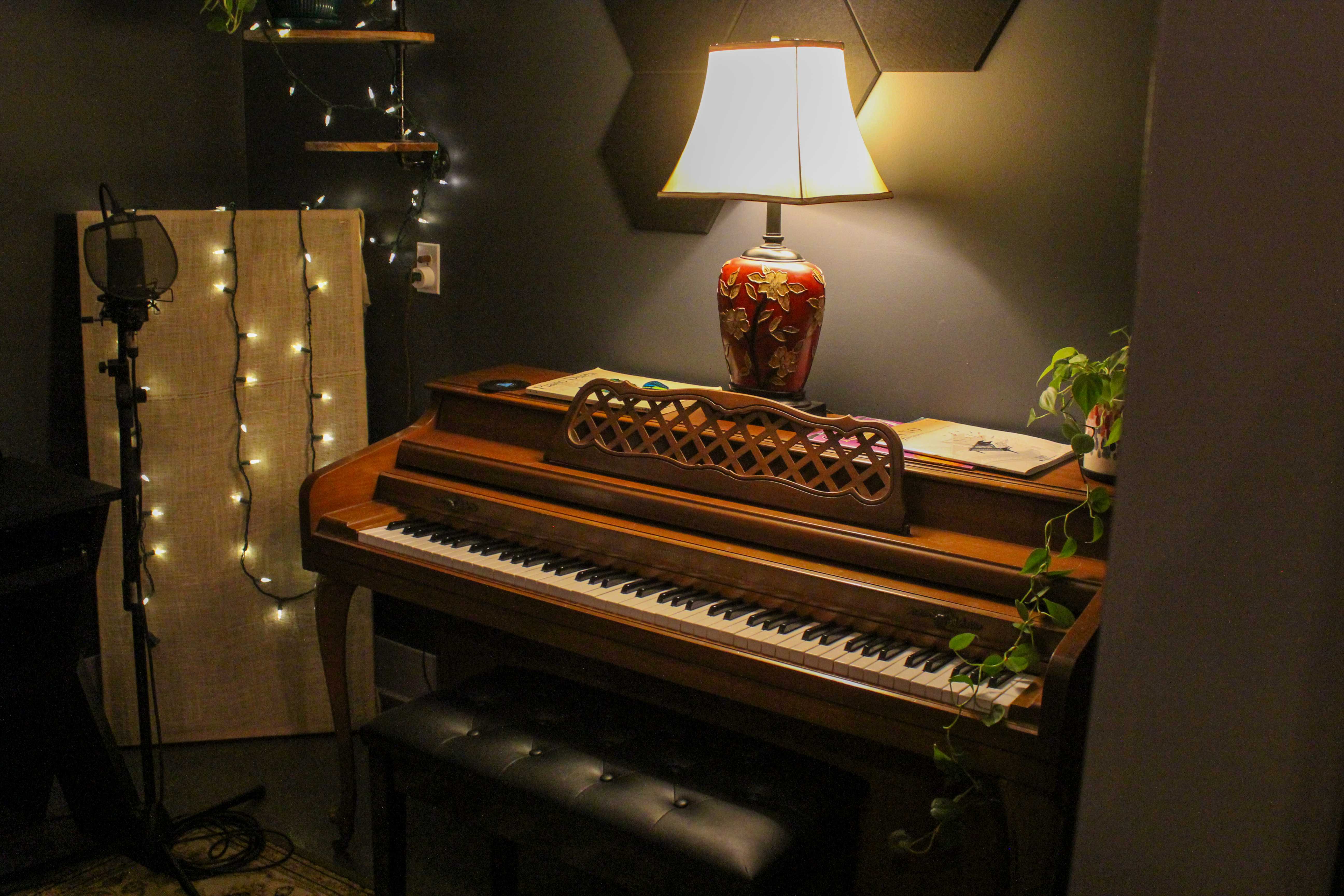 A vintage piano mic'd up and lit for a recording session in the studio